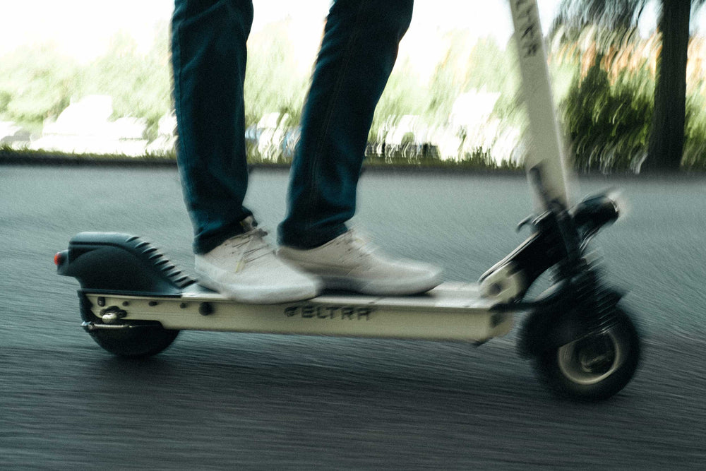 a man riding a white eltra urban electric scooter 