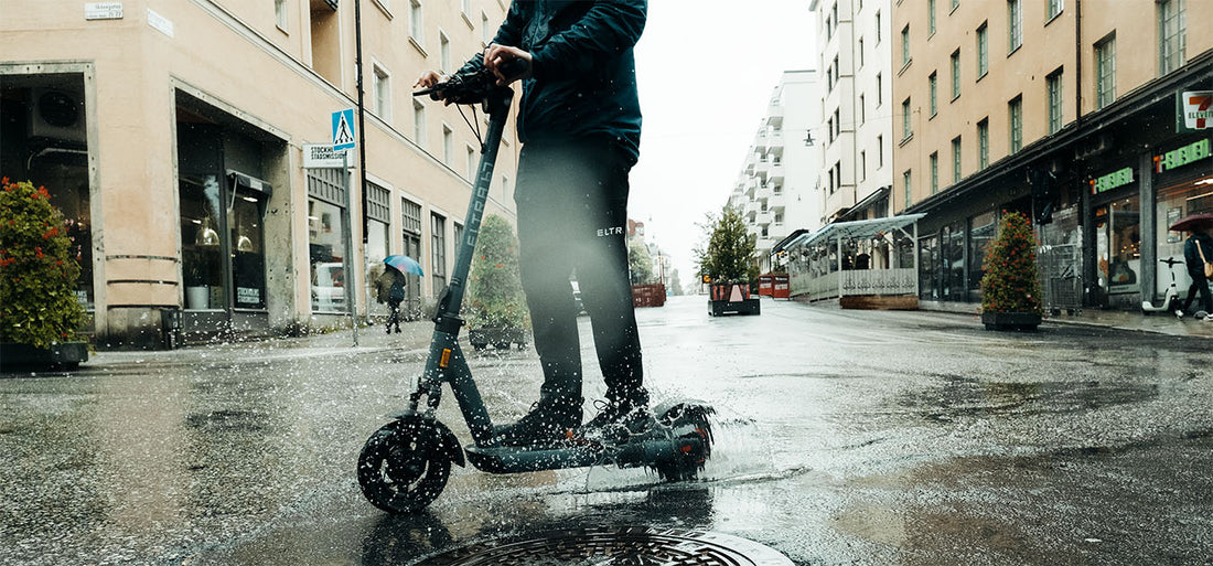A man riding a Eltra 67 electric scooter in the rain